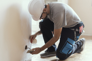 electrician fitting plug socket in a new build